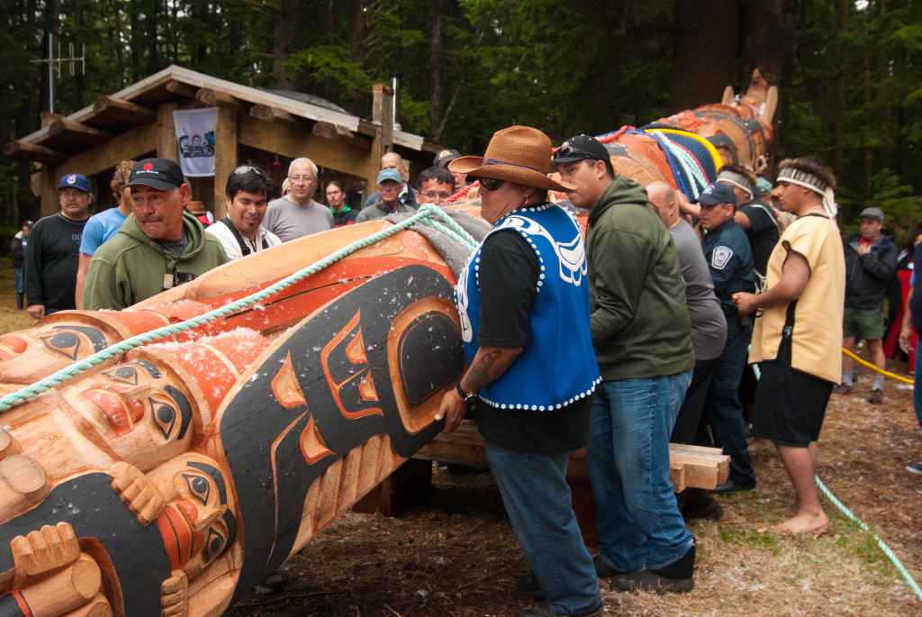 Member of the Haida Nation raise a totem pole in 