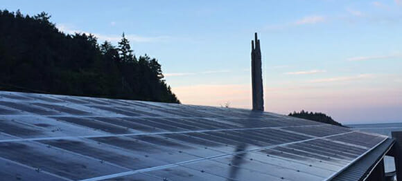 Solar panels now cover the longhouse roofs of the Haida Heritage Centre at Ḵay Llnagaay. Photo by VoVo Productions.