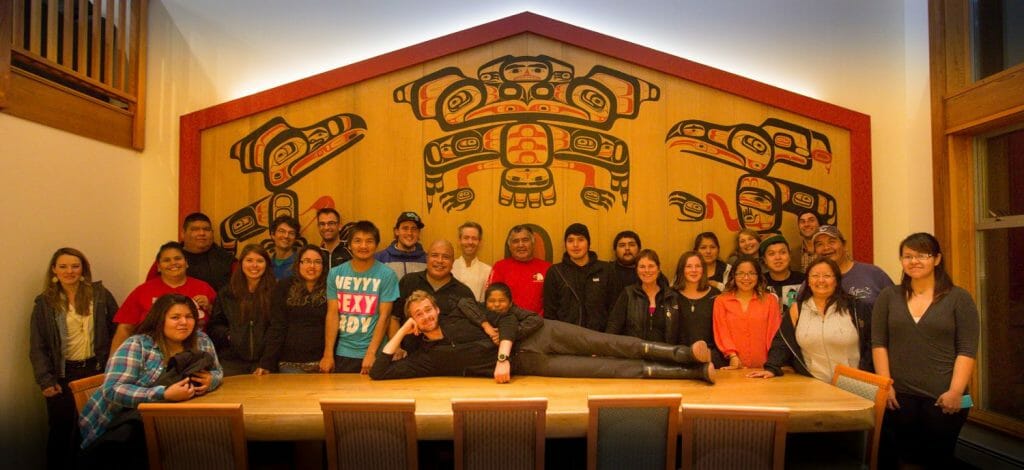 Spirit Bear Lodge Staff are pictured in the great room. Art was recreated from a photo of a Klemtu big house from 1886. Photo by Cael Cook courtesy of Spirit Bear Lodge.
