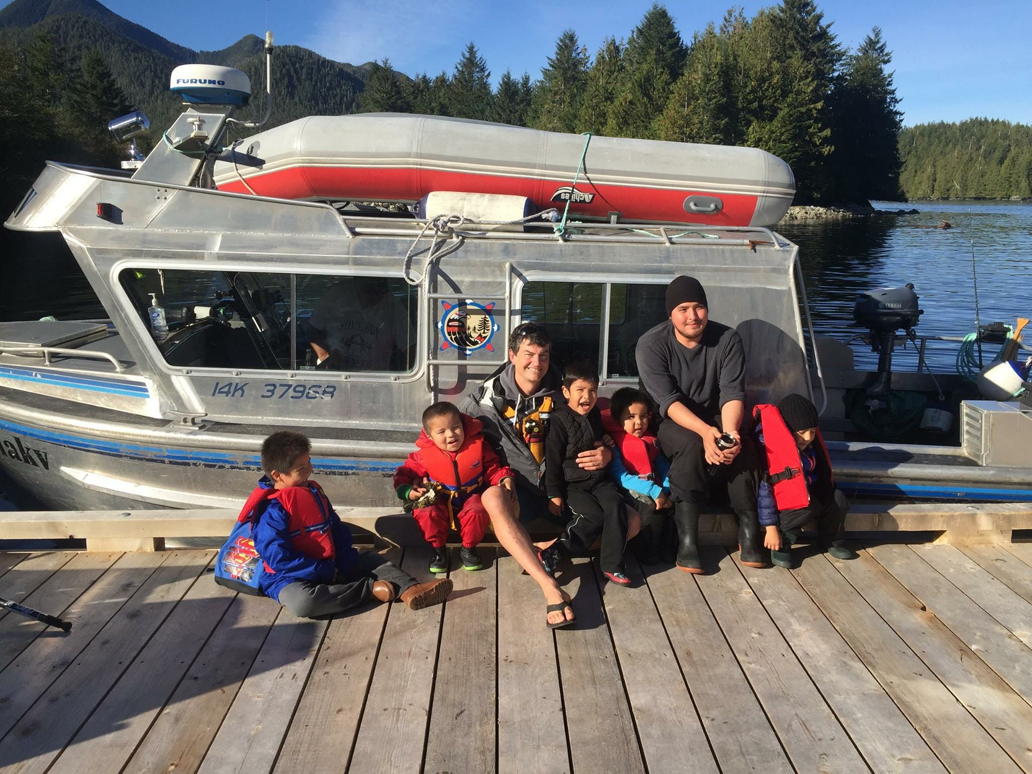Tim McGrady with guide Vernon Brown and local children. Photo courtesy of Spirit Bear Lodge.