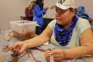 Gloria Walkus teaches cedar weaving to visitors as one of many workshops offered by k̓awat̕si Tours. 
