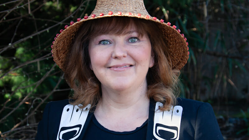 Tamara Davidson - smiling woman wearing a cedar hat and Haida regalia
