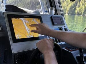 man points to a creek on a GPS map