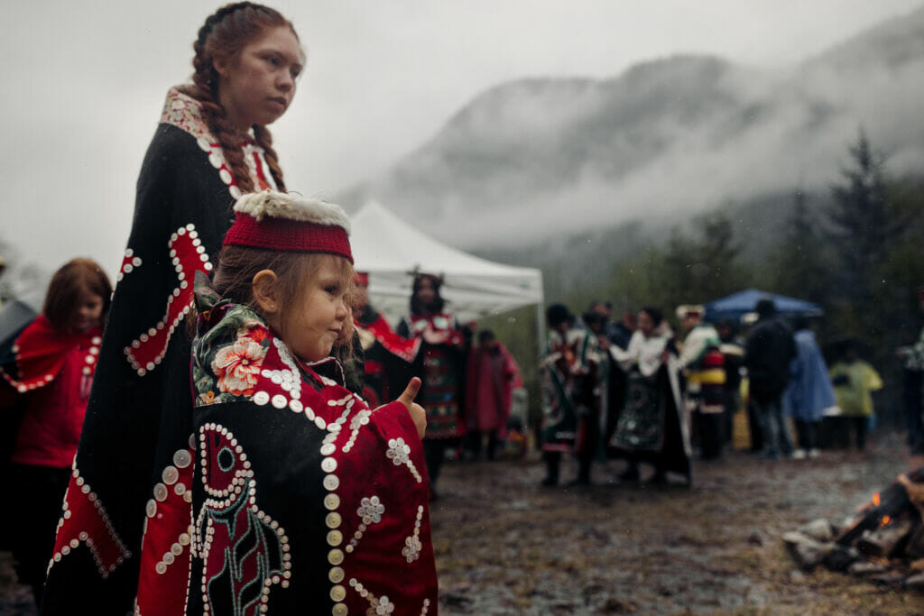 two girls in regalia dance in a circle on their Nation's homelands