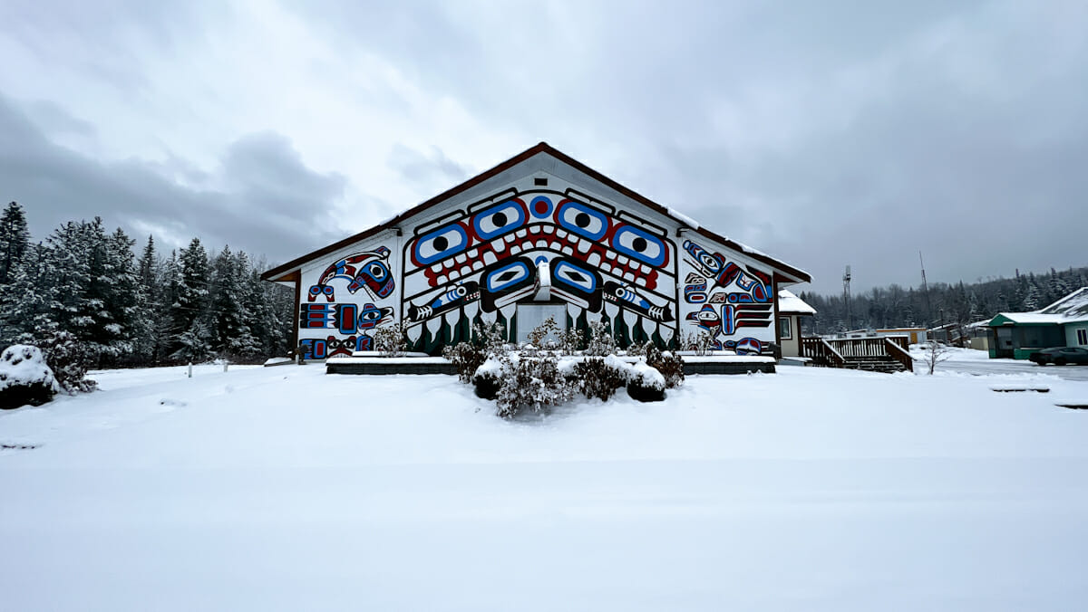 Indigenous community hall - white building with red, blue, and black painted designs.