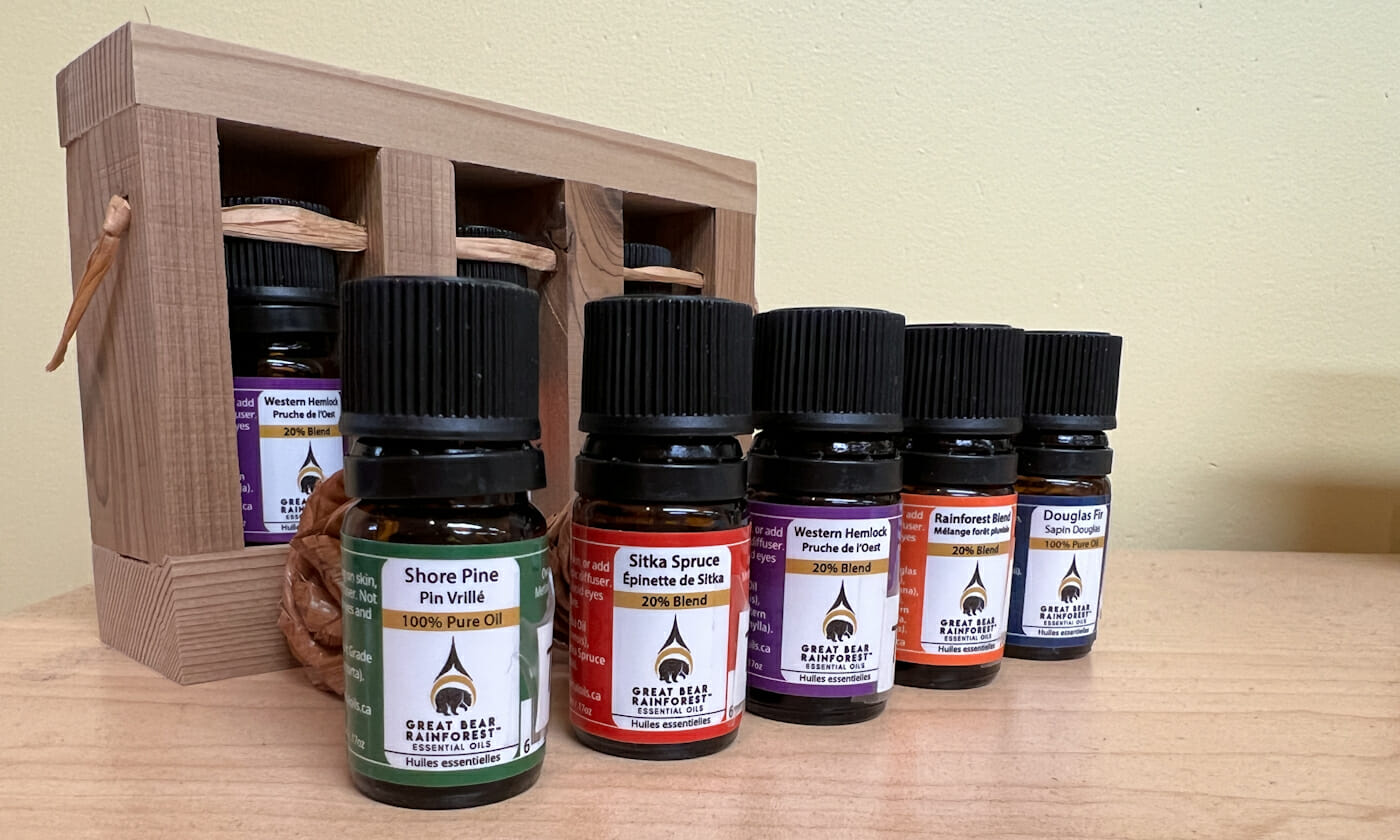 close-up photo of a set of essential oils lined up, with a cedar box behind.