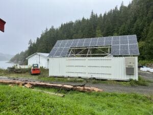 white-painted shipping container topped with solar panels