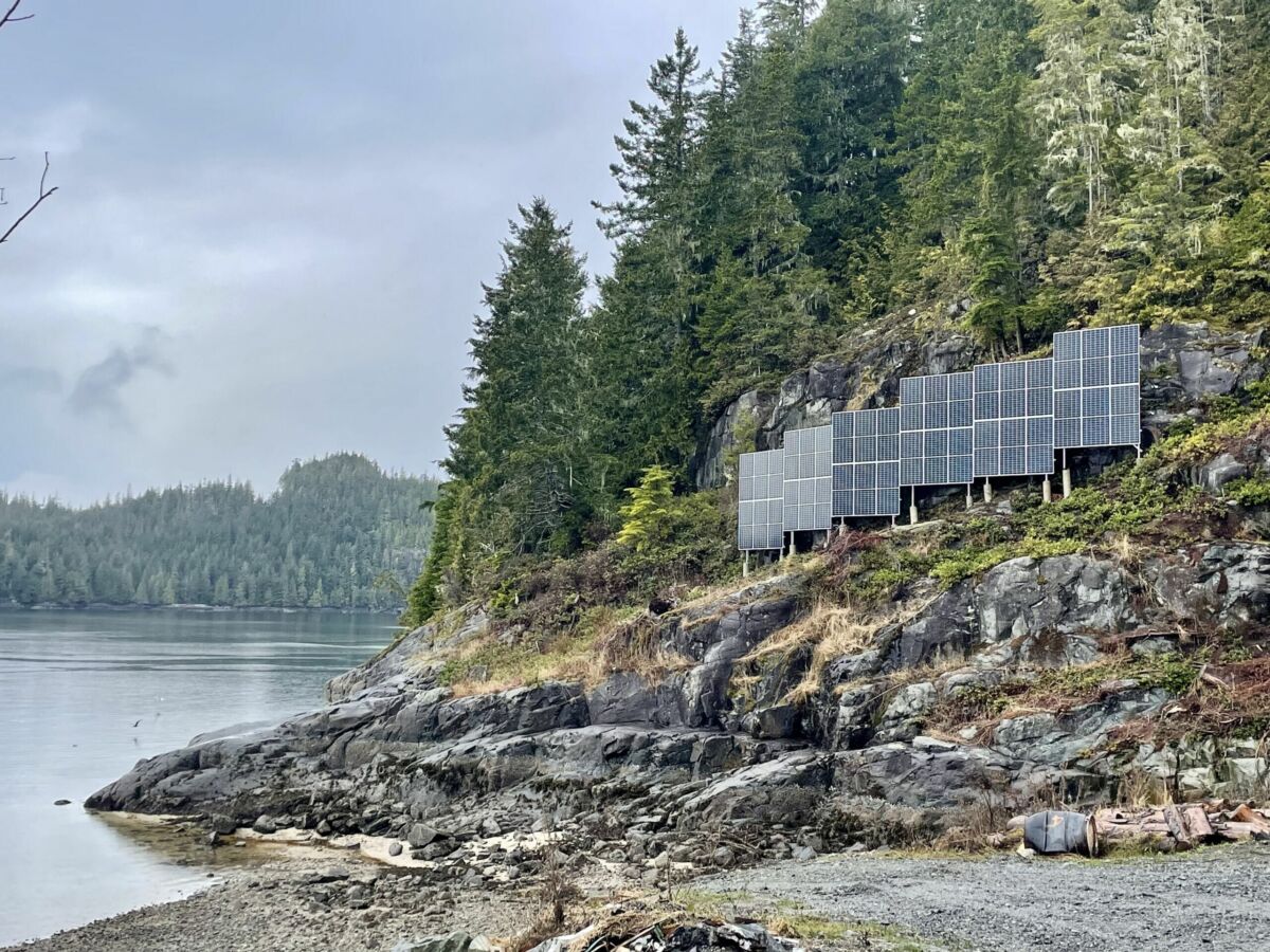 solar panels stand against a cliffside