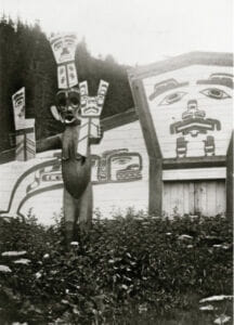 black and white photo of a carved figure holding up coppers