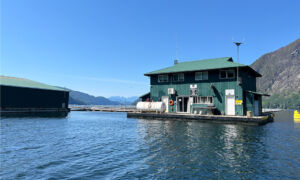 green house floats on the water, with mountains in the background