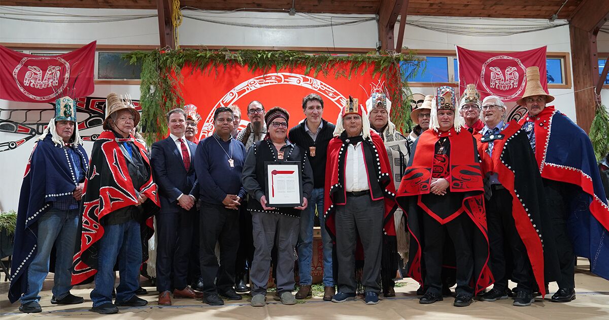 Haida Hereditary Leaders, Council of the Haida Nation President and Vice-President, alongside representatives from the Province of BC and the Government of Canada, stand together holding the signed Chiix̲uujin | Chaaw K̲aawgaa Agreement—a historic recognition of Haida title. (Photo: Rhea Botel / Council of the Haida Nation)