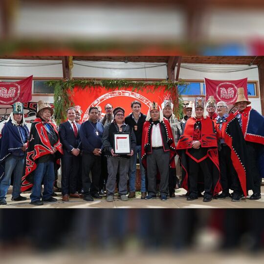 Haida Hereditary Leaders, Council of the Haida Nation President and Vice-President, alongside representatives from the Province of BC and the Government of Canada, stand together holding the signed Chiix̲uujin | Chaaw K̲aawgaa Agreement—a historic recognition of Haida title. (Photo: Rhea Botel / Council of the Haida Nation)