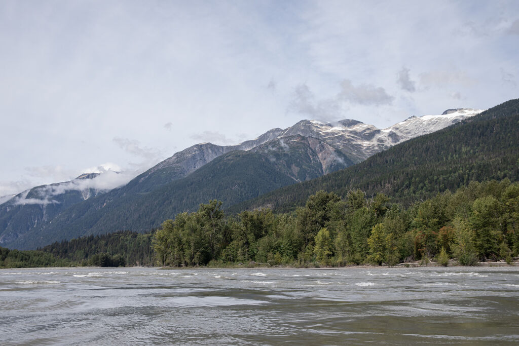 Stunning rolling mountains surrounding the Nass River peak through soft clouds.