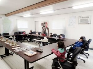 Children gather around a U shaped table.
