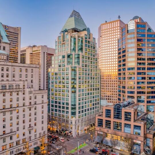 A photograph of Cathedral Place, the building that Coast Funds is moving to. The building is in a postmodern style with dusty copper accents and roofing. It was completed in the 90s and is very beautiful.