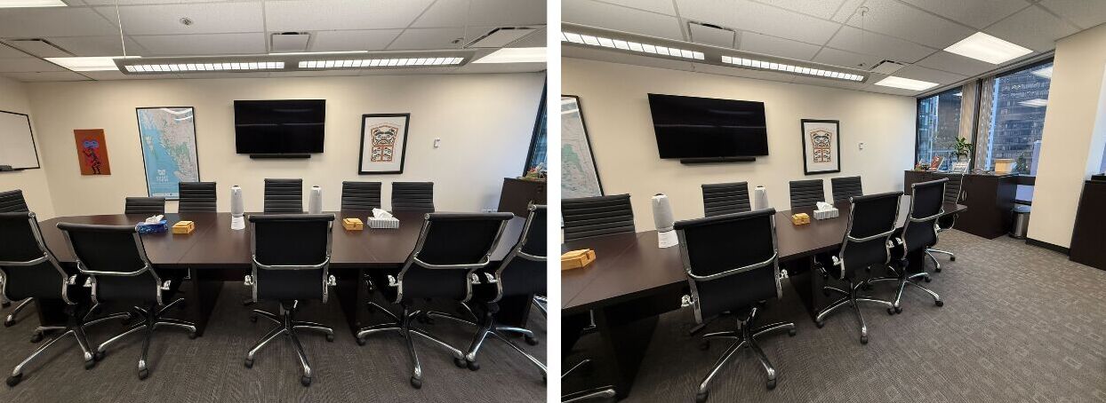 A photograph of Coast Funds' board room. The room is long and has a large dark wood oval shaped table. There are many chairs around the table. On the right side are two large floor-length windows looking out over the city.